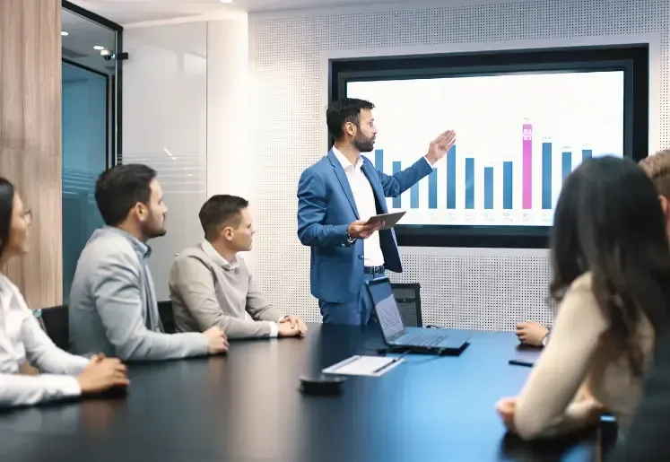 Businessman presenting growth chart data to team in a conference room
