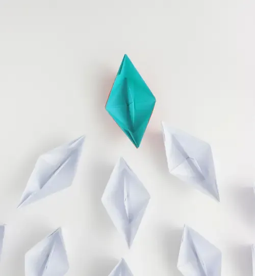 Illustration of a teal paper boat leading white paper boats, symbolizing leadership