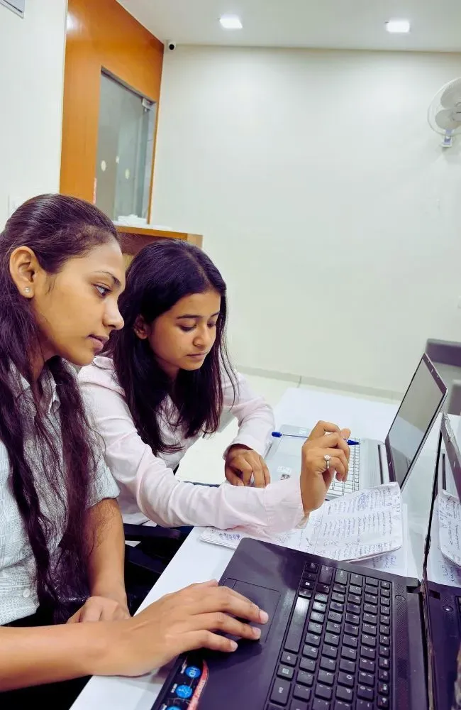 Adept Digitals employees discussing work over laptops